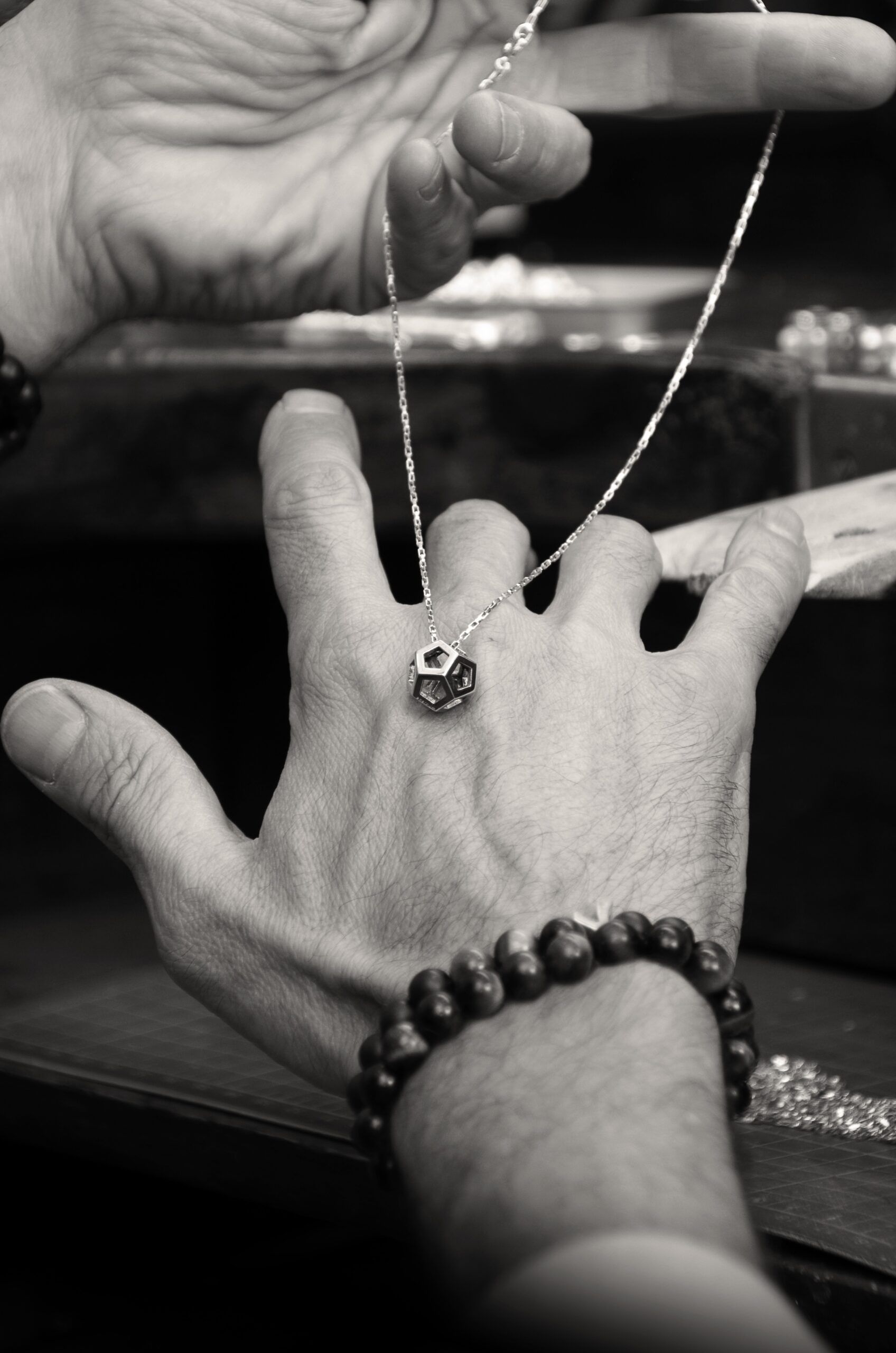 Mano con un colgante Enernum en el taller